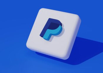 آیکون سه بعدی و مینیمال لوگوی پی‌پل (PayPal) با سایه‌پردازی روی پس‌زمینه آبی.