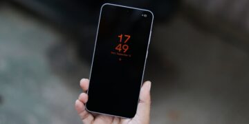 نمای نزدیک از یک گوشی هوشمند در دست با صفحه نمایش همیشه روشن (AOD).