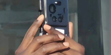 نمای پشت گوشی هوشمند (منتسب به شیائومی ۱۷ اولترا) در دستان کاربر، که درون یک قاب محافظ سیاه قرار دارد و چیدمان لنزهای دوربین از میان بریدگی‌های قاب پیداست.