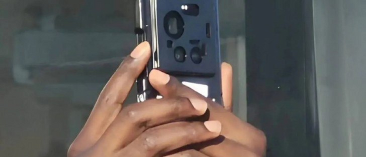 نمای پشت گوشی هوشمند (منتسب به شیائومی ۱۷ اولترا) در دستان کاربر، که درون یک قاب محافظ سیاه قرار دارد و چیدمان لنزهای دوربین از میان بریدگیهای قاب پیداست.