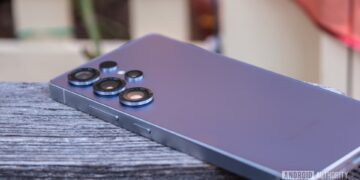 گوشی پرچمدار سامسونگ با بدنه بنفش رنگ که روی سطح چوبی قرار گرفته و لنزهای دوربین سهگانه آن دیده میشود.