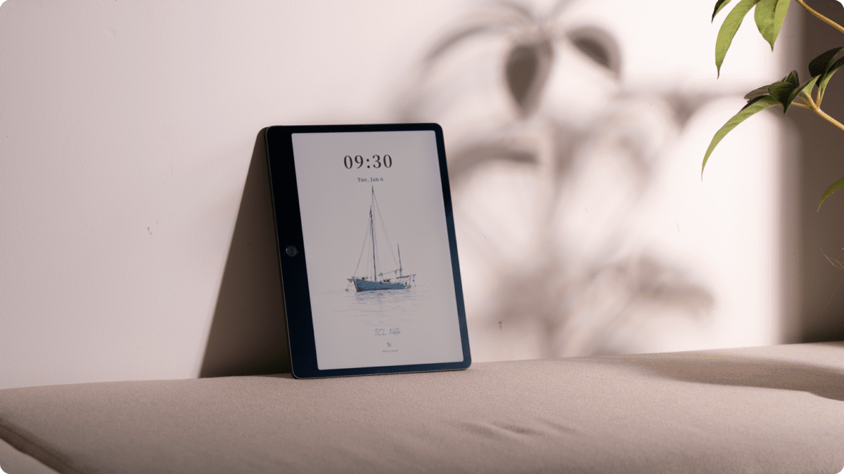 تبلت TCL Note A1 تکیه داده شده به دیوار که یک طرح خطی از قایق بادبانی و ساعت دیجیتال را نشان می‌دهد.