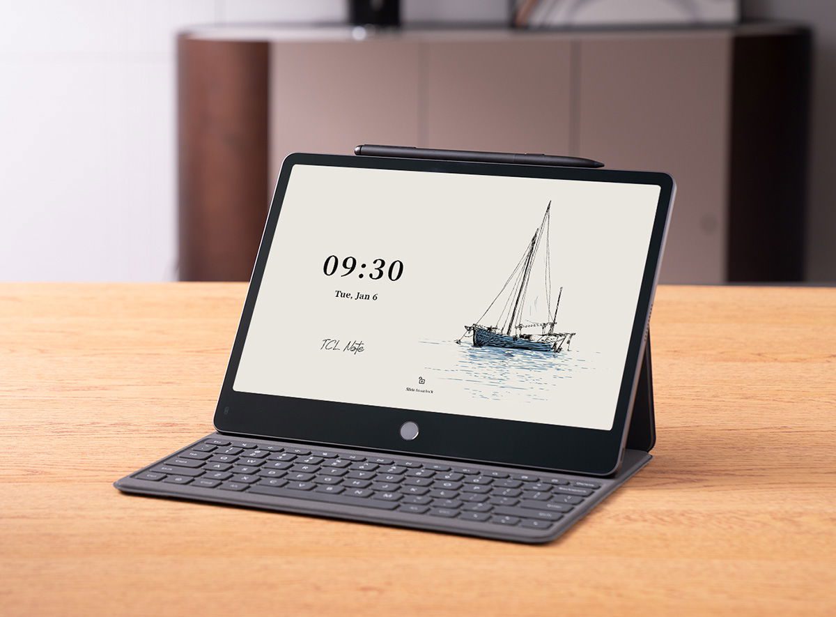 تبلت TCL Note A1 متصل به کیبورد روی میز چوبی همراه با قلم استایلوس در لبه بالایی.