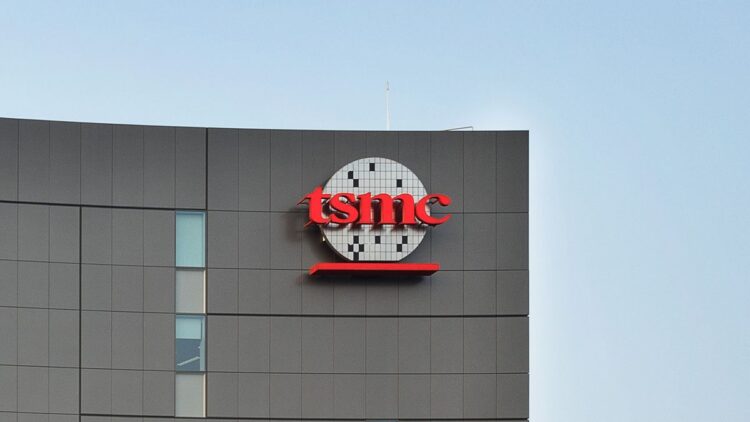 نمای خارجی یک ساختمان مدرن که لوگوی قرمز رنگ شرکت TSMC روی دیواره خاکستری آن نصب شده است.