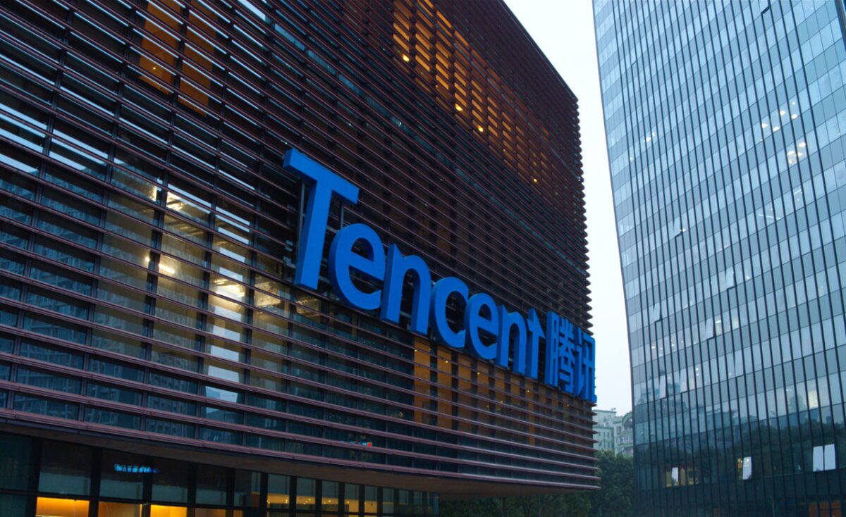 نمای بیرونی ساختمان اداری Tencent با نمای مدرن شیشه‌ای و فلزی، لوگوی آبی Tencent همراه با نوشته چینی روی نمای ساختمان، در میان برج‌های اداری شهری