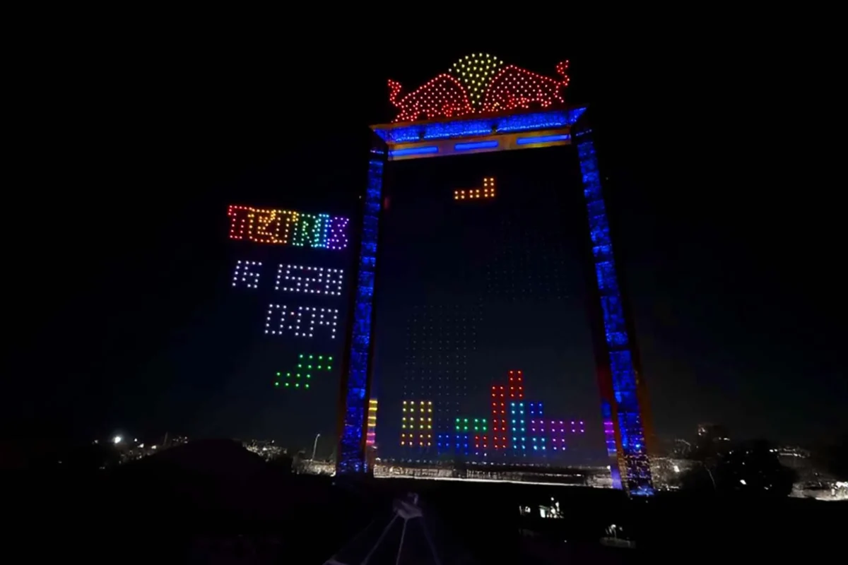 نمای شبانه از اجرای تتریس غولپیکر با پهپادهای هماهنگ در فینال جهانی Red Bull Tetris، ترکیب نورهای رنگی و معماری شهری دبی