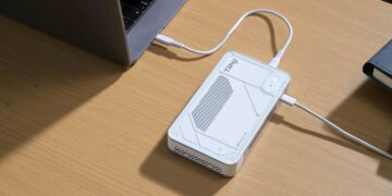 دستگاه پردازشگر کوچک هوش مصنوعی Tiiny متصل به لپتاپ روی میز کار.