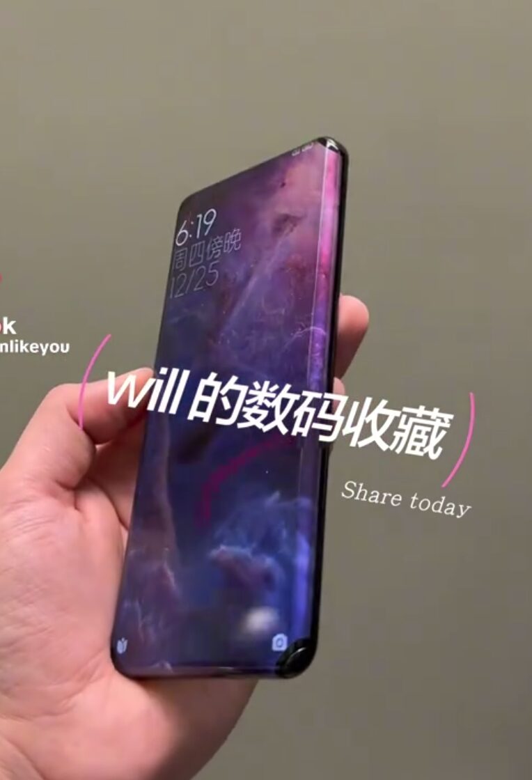 گوشی هوشمند با نمایشگر خمیده و پس‌زمینه بنفش که در دست گرفته شده است.