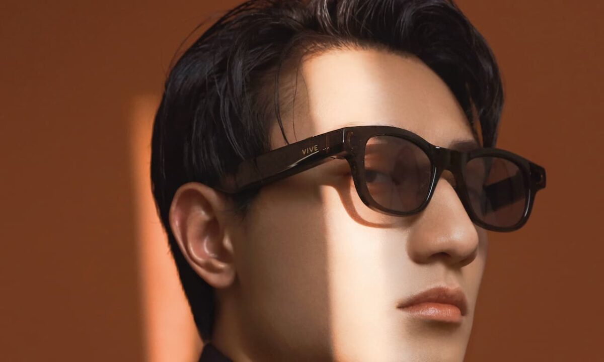 مردی با عینک هوشمند VIVE با فریم تیره و طراحی کلاسیک زیر نور آفتاب.