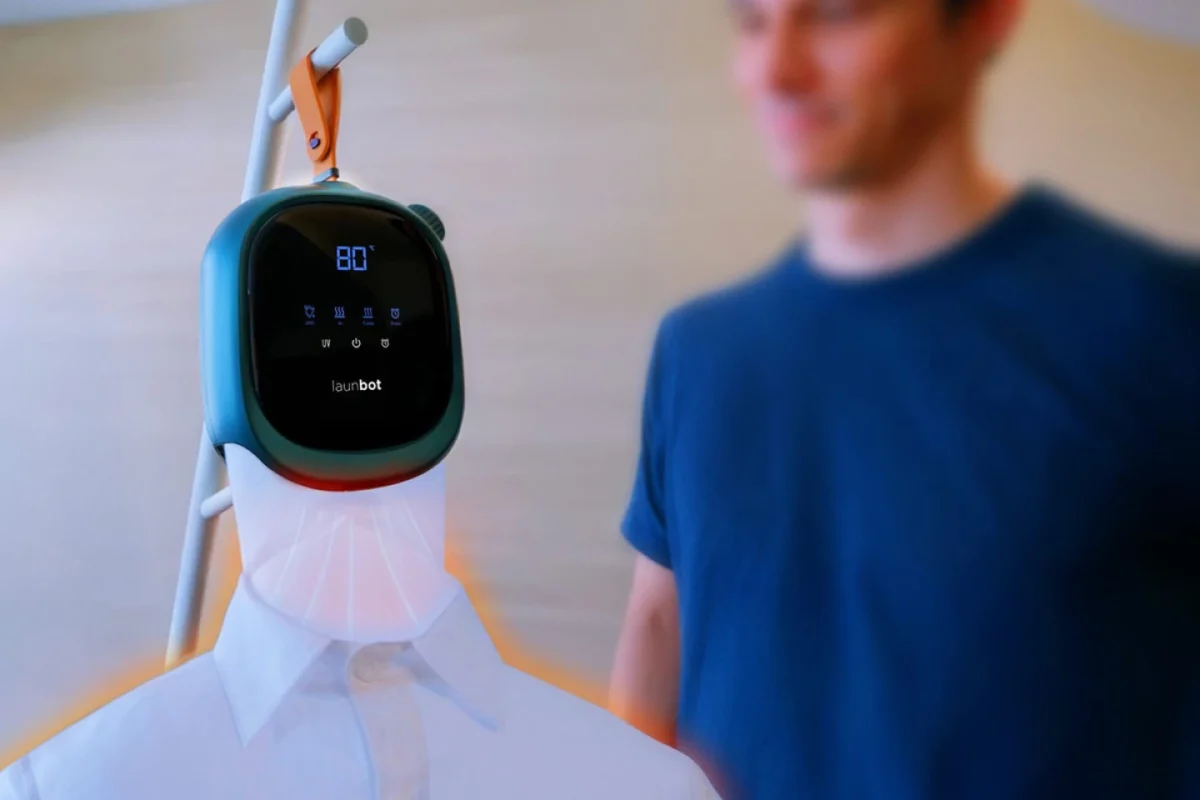 دستگاه Launbot آویزان‌شده در محیط داخلی در کنار یک کاربر، در حال عملکرد برای خشک‌کردن و از بین بردن چین‌وچروک پیراهن
