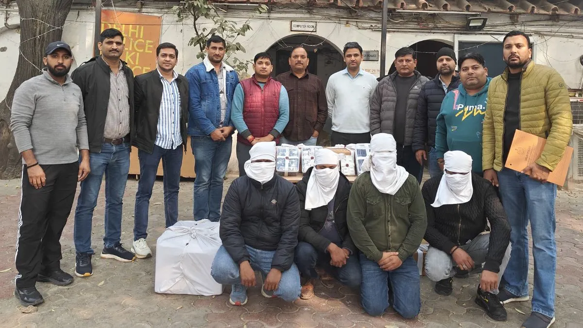 ماموران پلیس هند در کنار متهمان (با صورت پوشیده) و بسته‌های حاوی گوشی‌های سامسونگ تقلبی کشف شده.