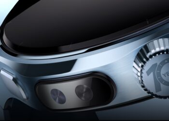 نمای کلوزآپ از بدنه جانبی ساعت هوشمند با قاب برس‌خورده، دکمه کناری، سنسورهای سلامتی و تاج چرخان با نشان سالگرد طراحی، تمرکز بر جزئیات مهندسی و ساخت