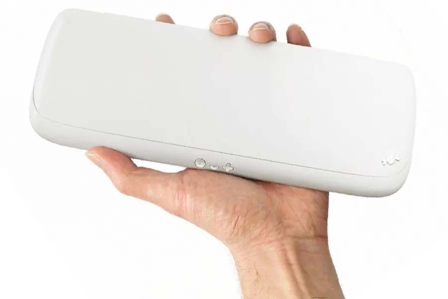 نمای پشت کنسول بازی دستی سفید و مینیمال که در کف دست نگه داشته شده است.