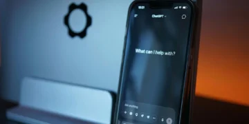 رندر سه‌بعدی یک ربات کارتونی سفید در کنار ماکتی از صفحه‌نمایش گوشی هوشمند با رابط گفت‌وگویی، نماد تعامل بین چت‌بات‌ها و اپلیکیشن‌های پیام‌رسان مبتنی بر هوش مصنوعی