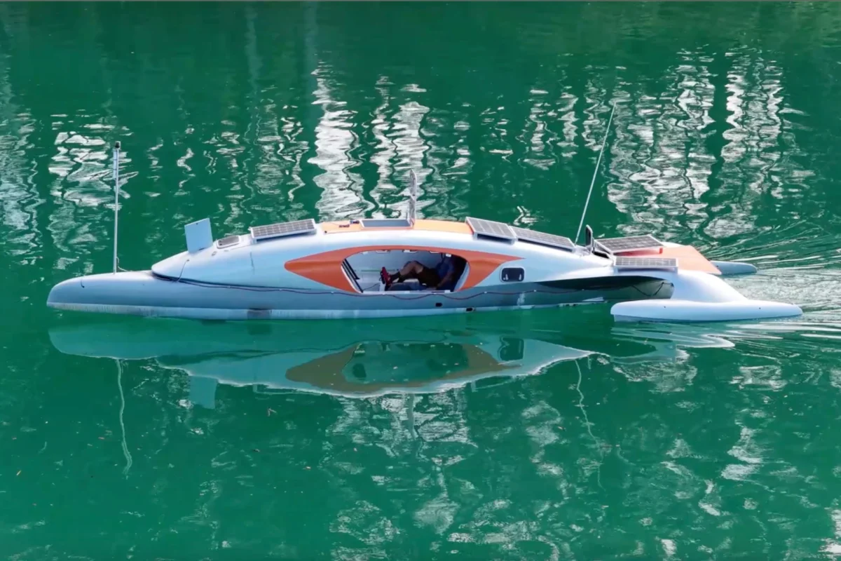 نمای جانبی قایق پدالی سه‌بدنه در آب، کابین مرکزی و جایگاه پدال‌زدن برای سفرهای طولانی دریایی