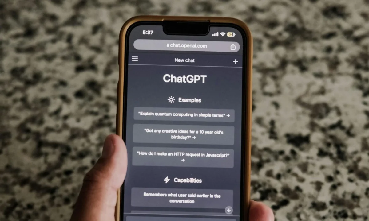 نمای صفحه ChatGPT روی گوشی هوشمند با آدرس chat.openai.com، نمایش نمونه پرسش‌ها، قابلیت‌ها و رابط کاربری نسخه موبایل سرویس هوش مصنوعی OpenAI