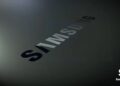 نمای نزدیک و زاویه‌دار از لوگوی نوشتاری سامسونگ با بافت تیره و براق روی یک سطح خاکستری.