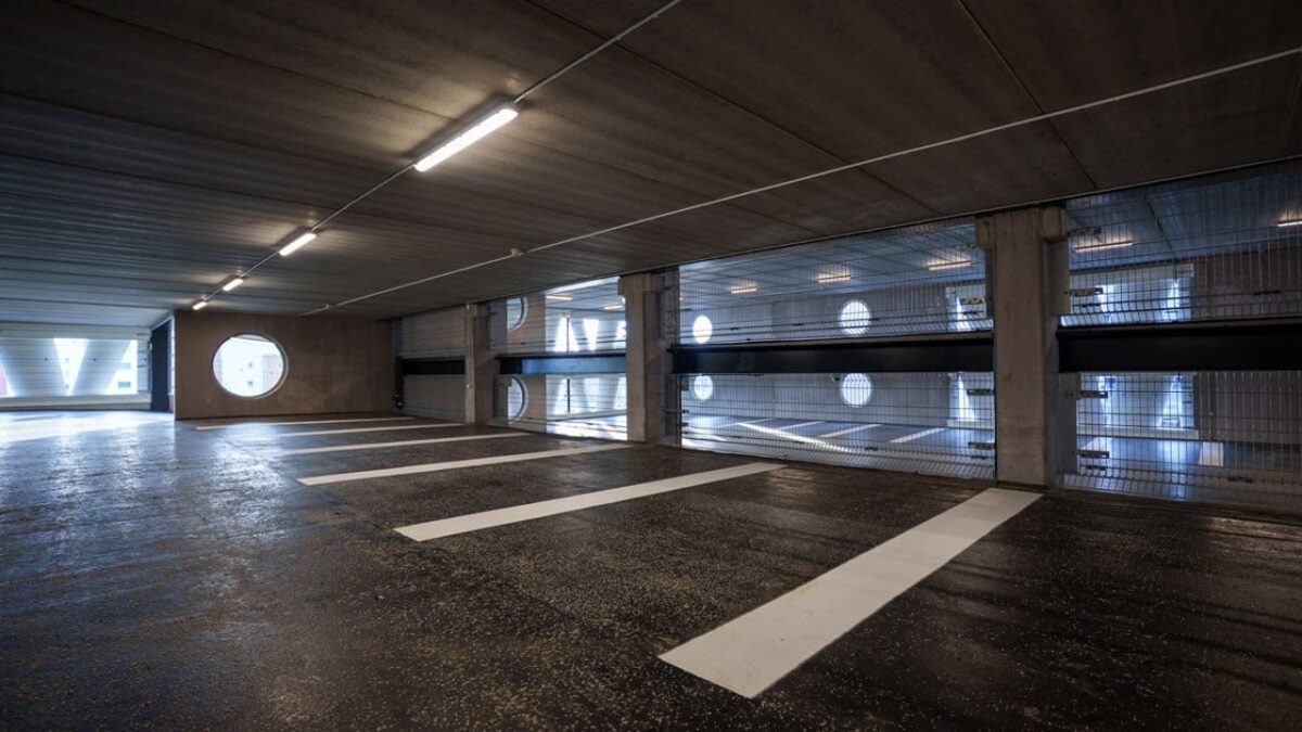 نمای داخلی پارکینگ چندطبقه نیلز بور در لوند با طراحی مدرن، نورپردازی خطی و دیوارهای پرده‌ای ساخته‌شده از پره‌های بازیافتی توربین بادی.