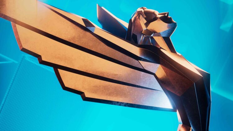 نمای نزدیک از تندیس نمادین The Game Awards با طراحی هندسی و رنگ طلایی، در پس&zwnj;زمینه آبی روشن و سبک گرافیکی رسمی مراسم