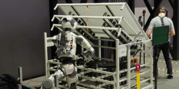 ربات انسان‌نمای اطلس در خط تولید آزمایشی هیوندای، در حال انجام عملیات مونتاژ در کنار نیروی انسانی و تجهیزات خودکار.