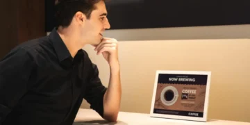 نمای محیطی از یک نمایشگر رومیزی سامسونگ روی کانتر، در حال نمایش محتوای تبلیغاتی نوشیدنی با تیتر Now Brewing Coffee؛ تأکید بر روشنایی یکنواخت، خوانایی بالا و کاربرد نمایشگر دیجیتال در فضاهای تجاری و کافیشاپ.