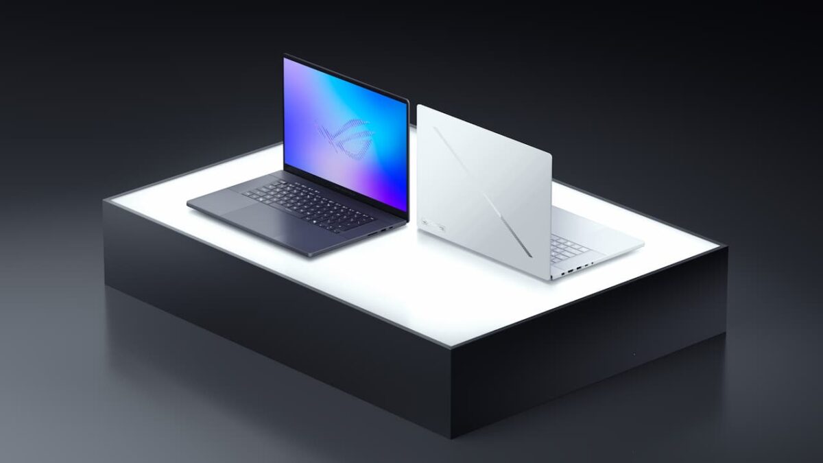 رندر تبلیغاتی دو لپ‌تاپ Zephyrus G16 در رنگ‌های سفید و خاکستری تیره روی سکوی نوری.