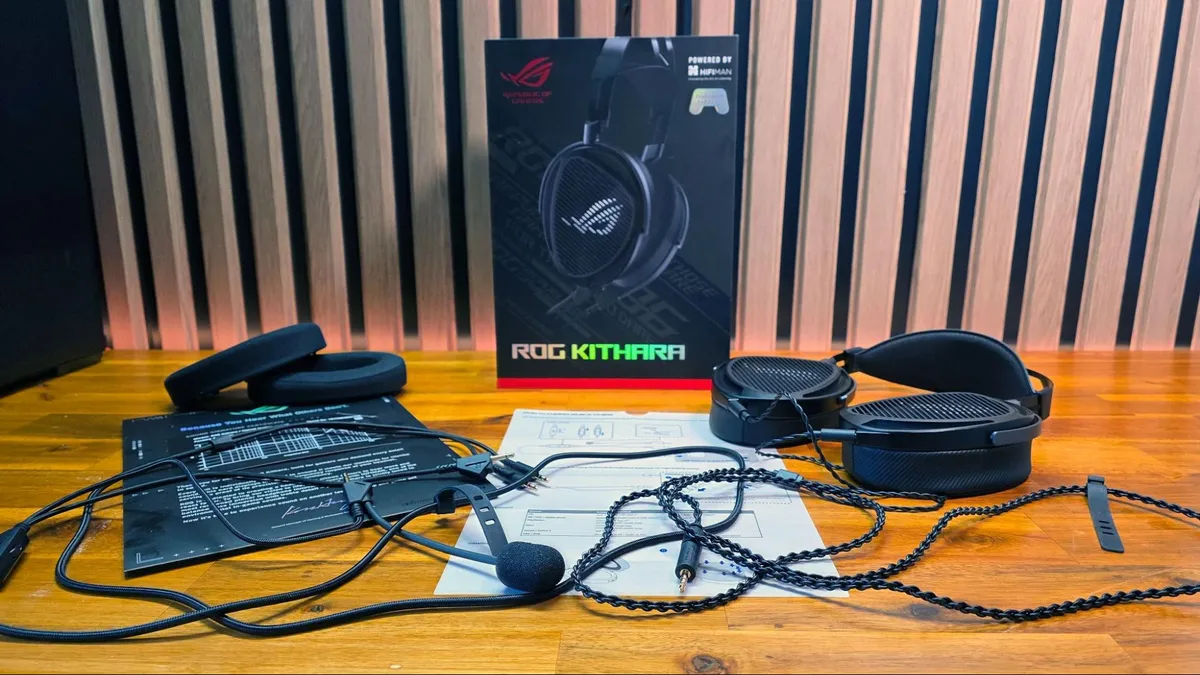 پکیج کامل محصول شامل هدست ROG Kithara، میکروفون جداشونده، کابلهای رابط، پدهای اضافه و جعبه اصلی روی میز.