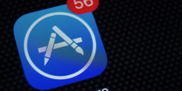 نمای نزدیک از آیکون برنامه اپ استور (App Store) بر روی صفحه نمایش موبایل با یک اعلان قرمز عدد ۵۶.