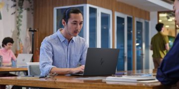 فردی در حال کار با لپ‌تاپ جدید HP در یک فضای اداری مدرن.