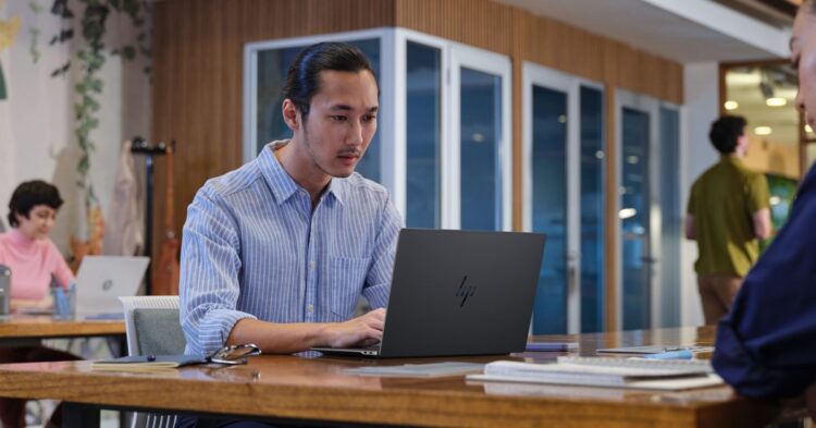 فردی در حال کار با لپ‌تاپ جدید HP در یک فضای اداری مدرن.