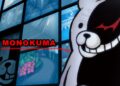 اسکرین‌شات از رابط کاربری بازی Danganronpa، نمایش نمای نزدیکی از عروسک خرس سیاه و سفید Monokuma در سمت راست، و متن MONOKUMA با فونت قرمز، در مقابل دیواری از مانیتورهای کوچک نمایشگر محیط داخلی و خارجی.