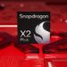 نمای نزدیک از لوگوی پردازنده Qualcomm Snapdragon X2 Plus بر روی یک مدار چاپی قرمز رنگ.