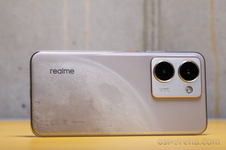 نمای پشت یک گوشی هوشمند برند Realme با رنگ نقرهای طرحدار و دوربین دوتایی در بالا سمت راست.
