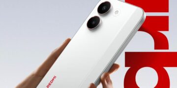 نمای زاویهدار از پنل پشتی Redmi Turbo 5 با بدنه سفید مات، ماژول دوربین دوگانه عمودی با حلقههای مشکی برجسته، فلش LED تکی، لبههای تخت فلزی و لوگوی REDMI؛ پسزمینه گرافیکی با تایپوگرافی قرمز.