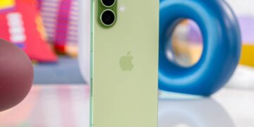 نمای پشت یک گوشی آیفون به رنگ سبز روشن با دو لنز بزرگ دوربین که روی میز قرار دارد.