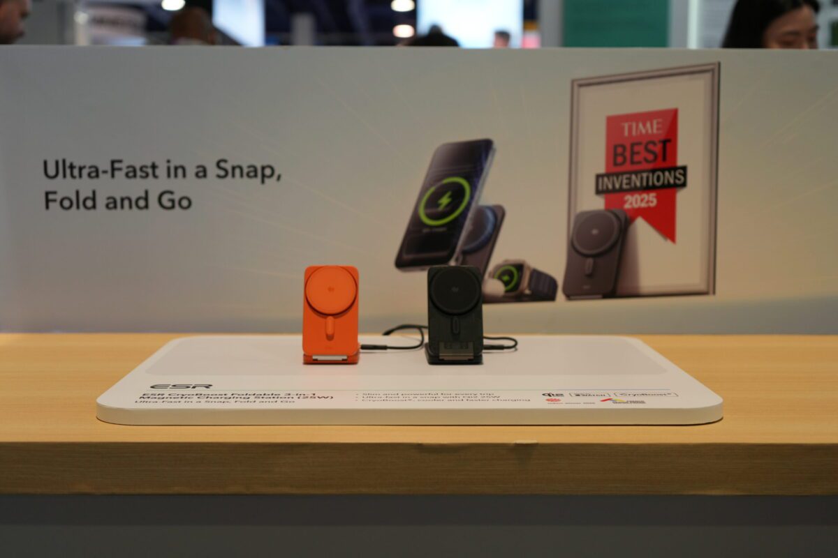 دو عدد شارژر تاشو ESR به رنگ‌های نارنجی و مشکی که روی یک استند سفید در نمایشگاه قرار گرفته‌اند.