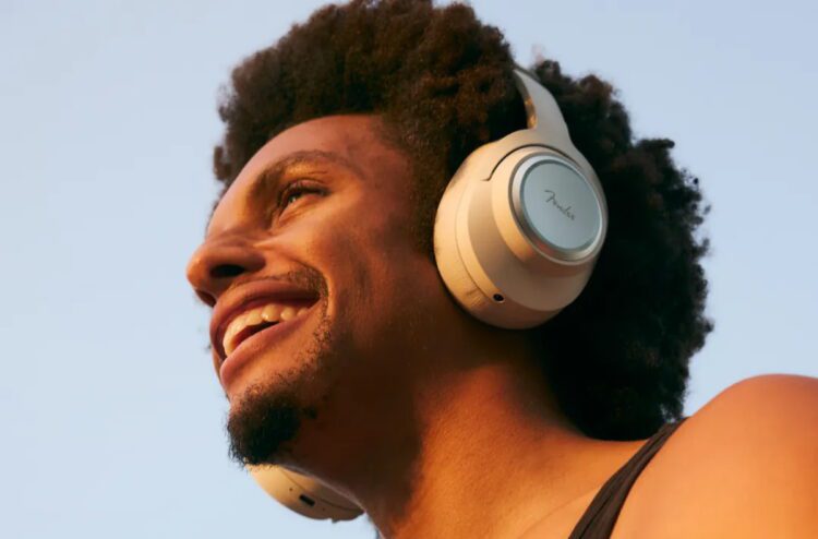 نمای جانبی هدفون روگوشی Fender روی سر، با طراحی مینیمال، کاپ دایرهای فلزی، هدبند ساده و نورپردازی طبیعی محیطی