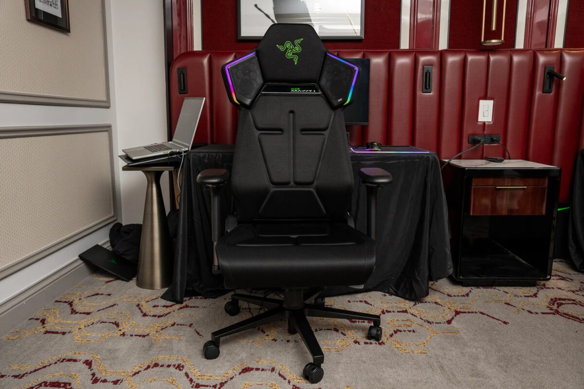 نمای روبه‌روی صندلی گیمینگ Razer Project Madison در فضای داخلی، با طراحی ارگونومیک، پایه چرخ‌دار، دسته‌های قابل تنظیم و میز گیمینگ مجهز به نمایشگر و تجهیزات RGB در پس‌زمینه