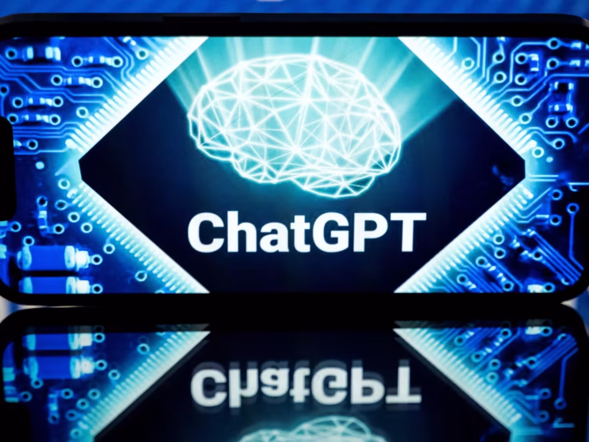 نمای نزدیک از یک گوشی هوشمند در حال نمایش لوگوی ChatGPT که طرحی از یک شبکه مغزی متصل به مدارهای الکترونیکی درخشان (Brain Network) را نشان می‌دهد. پس‌زمینه آبی تیره و بازتاب نور روی صفحه، مفاهیم هوش مصنوعی، یادگیری عمیق و پردازش عصبی (Neural Processing) را تداعی می‌کند.