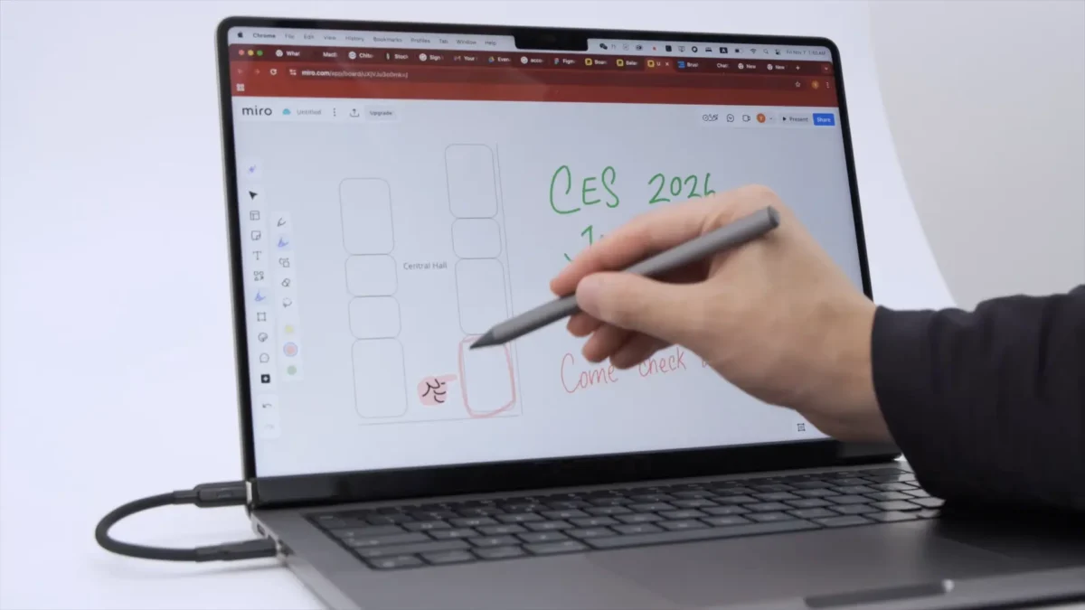 کاربری که با استفاده از یک قلم مخصوص (Stylus) در حال کار روی صفحه نمایش یک MacBook است که با یک اکسسوری به حالت لمسی درآمده است.