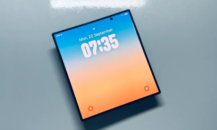 گوشی هوشمند سامسونگ با صفحه نمایش بزرگ و مربعی که ساعت ۰۷:۳۵ را روی یک پس‌زمینه رنگارنگ نشان می‌دهد.