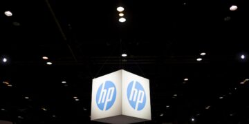 لوگوی معلق HP به شکل مکعب نورانی در فضای نمایشگاهی بزرگ با نورپردازی سقفی، مناسب رویدادهای فناوری و نمایشگاه‌های سخت‌افزار