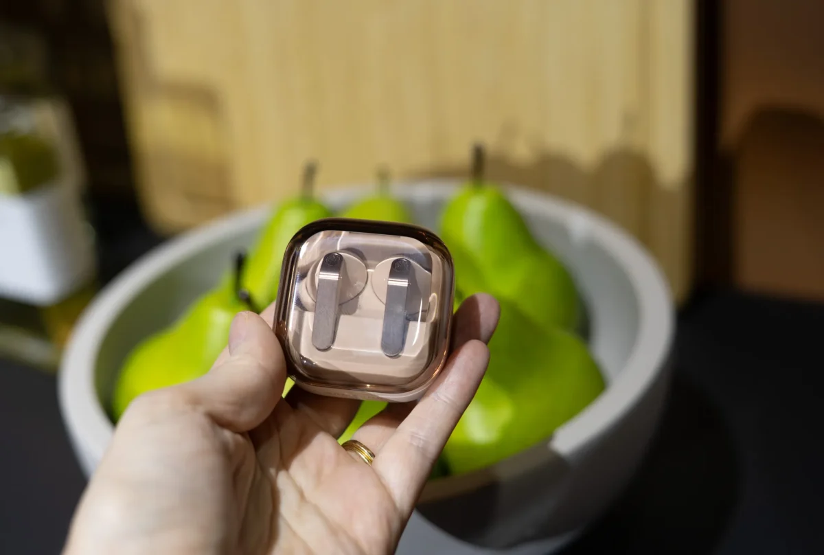 دو عدد ایرباد گلکسی بادز ۴ با بدنه نقره‌ای و طراحی پایه‌دار (Stem) در کف دست انسان.