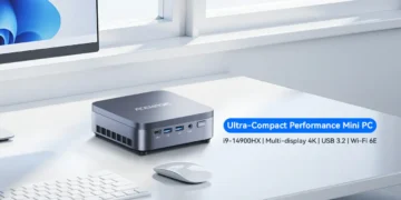 مینی پی‌سی خاکستری Acemagic روی میز کار در کنار موس و کیبورد با متن "Ultra-Compact Performance".