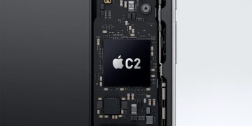 نمای داخلی یک گوشی هوشمند با تمرکز بر برد الکترونیکی و چیپ Apple C2 که به‌عنوان مودم 5G اختصاصی اپل روی مادربورد نصب شده است؛ لوگوی اپل و نام C2 روی تراشه دیده می‌شود و اطراف آن با قطعات ریز الکترونیکی احاطه شده که نشان‌دهنده یکپارچگی سخت‌افزاری و توسعه فناوری ارتباطی داخلی اپل است.