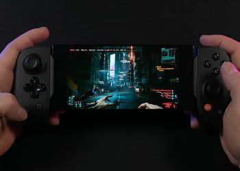 نمای یک گوشی هوشمند که به کنترلر گیمینگ فیزیکی دوطرفه متصل شده و بازی Cyberpunk 2077 را در حالت نمای اول‌شخص اجرا می‌کند. تصویر خیابان‌های نئونی شهر Night City با نورپردازی سایبرپانکی روی نمایشگر دیده می‌شود و این صحنه اجرای بازی AAA روی موبایل را نمایش می‌دهد.