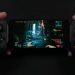 نمای یک گوشی هوشمند که به کنترلر گیمینگ فیزیکی دوطرفه متصل شده و بازی Cyberpunk 2077 را در حالت نمای اول‌شخص اجرا می‌کند. تصویر خیابان‌های نئونی شهر Night City با نورپردازی سایبرپانکی روی نمایشگر دیده می‌شود و این صحنه اجرای بازی AAA روی موبایل را نمایش می‌دهد.