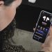 زنی که هندزفری Galaxy Buds Pro را در گوش دارد و در حال کار با اپلیکیشن مدیریت آن در گوشی است.