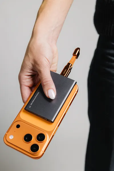 اتصال گوشی آیفون نارنجی به یک هارد اکسترنال سامسونگ T7 با استفاده از کابل کوتاه Nomad.