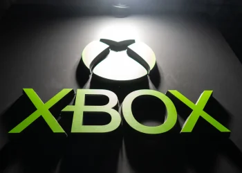لوگوی Xbox با نورپردازی سبز روی پس‌زمینه تیره، نمادی از برند Xbox و اکوسیستم بازی‌های ویدیویی مایکروسافت